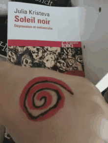 a book called soleil noir by julia kristeva has a spiral painted on it