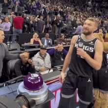 a man in a kings jersey stands in front of a crowd of people