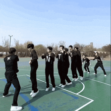 a group of young men are standing on a basketball court and one of them has the letter n on his shirt