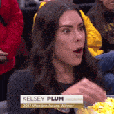 a woman named kelsey plum is eating popcorn at a game