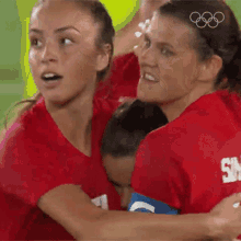 a group of female soccer players are hugging each other while wearing red jerseys with the letter s on them