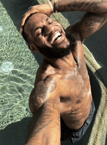 a shirtless man is taking a selfie with his eyes closed