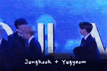 jungkook and yugyeom are standing next to each other in front of a blue background