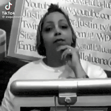 a woman is standing in front of a sign that says tiktok .