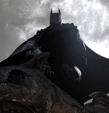 a batman standing on top of a rock with a full moon in the background