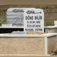 a grave in a cemetery with arabic writing on it .