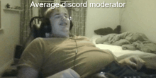 a man wearing headphones sits in front of a computer screen with the words average discord moderator above him