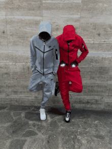 a man in a grey nike hoodie stands next to a man in a red hoodie