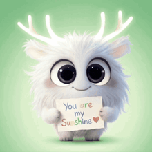 a stuffed animal with antlers holding a sign that says you are my sunshine