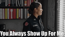 a woman in a firefighter uniform stands in front of a window with the words " you always show up for me " below her