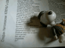 a snoopy figurine sits on top of a page with a poem on it