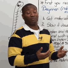 a man in a yellow and black striped shirt stands in front of a white board that says " first you read beginner "