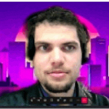 a man wearing headphones is looking at the camera with a city in the background .