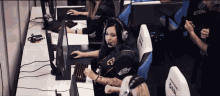 a woman wearing headphones sits at a desk in front of a computer with the word esl on the back of her shirt