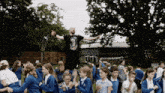 a man wearing a black shirt with a dragon on it is standing in front of a group of children