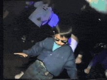a boy wearing sunglasses and a blue shirt is dancing