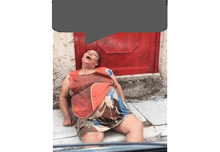 a woman is laying on the ground with a red door behind her