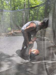 a man is kneeling on a trampoline with a basketball