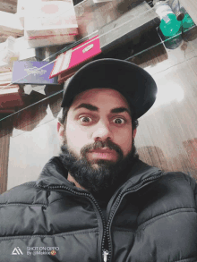 a man with a beard wearing a black jacket and a black hat takes a selfie with an oppo phone