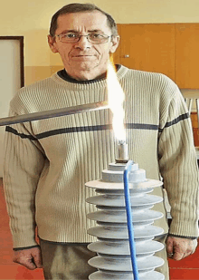 a man in a sweater is holding a torch and a candle