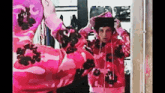 a person wearing a pink camo hoodie looks at themselves in a mirror .