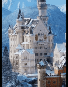 a snowy castle with mountains in the background and a clock tower