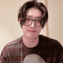 a man wearing glasses and a striped shirt