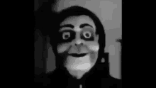 a black and white photo of a person wearing a creepy mask .