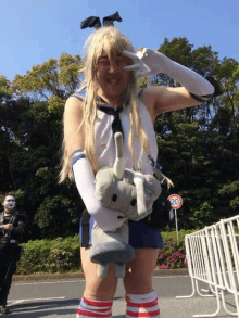 a man dressed in a bunny costume holds a stuffed elephant