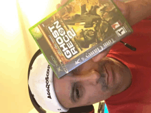 a man holds a copy of ghost recon 2 over his face