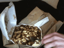 a styrofoam container filled with french fries and sauce