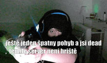 a man wearing headphones is holding a gun with the caption " jeste jeden spatny pohyb a isi dead "