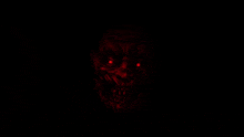 a close up of a scary clown with red eyes in the dark .