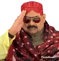 a man wearing sunglasses and a red turban is saluting in a photo taken with photoroom