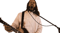 a man with long hair is singing into a microphone while holding a guitar