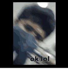 a blurry picture of a man wearing a mask and sunglasses with the words `` ok lol '' written below him .