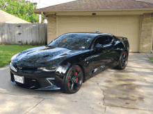 a black car with a texas license plate is parked in a driveway