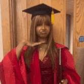 a woman in a graduation cap and gown is making a face