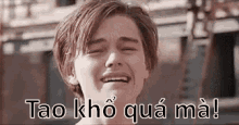 a young man is crying with his eyes closed and the words tao kho qua ma .