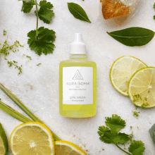 a bottle of aura-soma lime green pomade is surrounded by lemons and cilantro