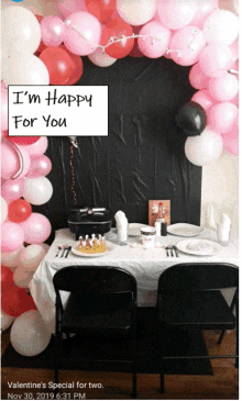 a valentine 's special for two is set up with balloons and a sign that says i 'm happy for you