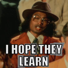 a man in a hat and glasses says i hope they learn