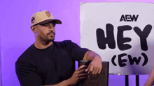 a man is standing in front of a sign that says hey ( ew )