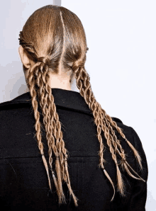 a woman with braids in her hair is wearing a black jacket .