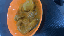 a close up of a bowl of curry on a wooden table