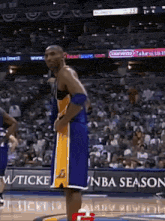 a basketball player stands on the court in front of an nba season sign