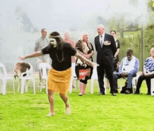 a woman in a yellow skirt is dancing in front of a crowd of people