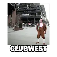 a man in a brown suit is standing in front of a building that says clubwest on it
