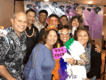 a group of people posing for a picture with one woman holding a sign that says " you rock "