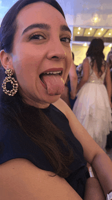 a woman with her tongue out wearing earrings and a watch